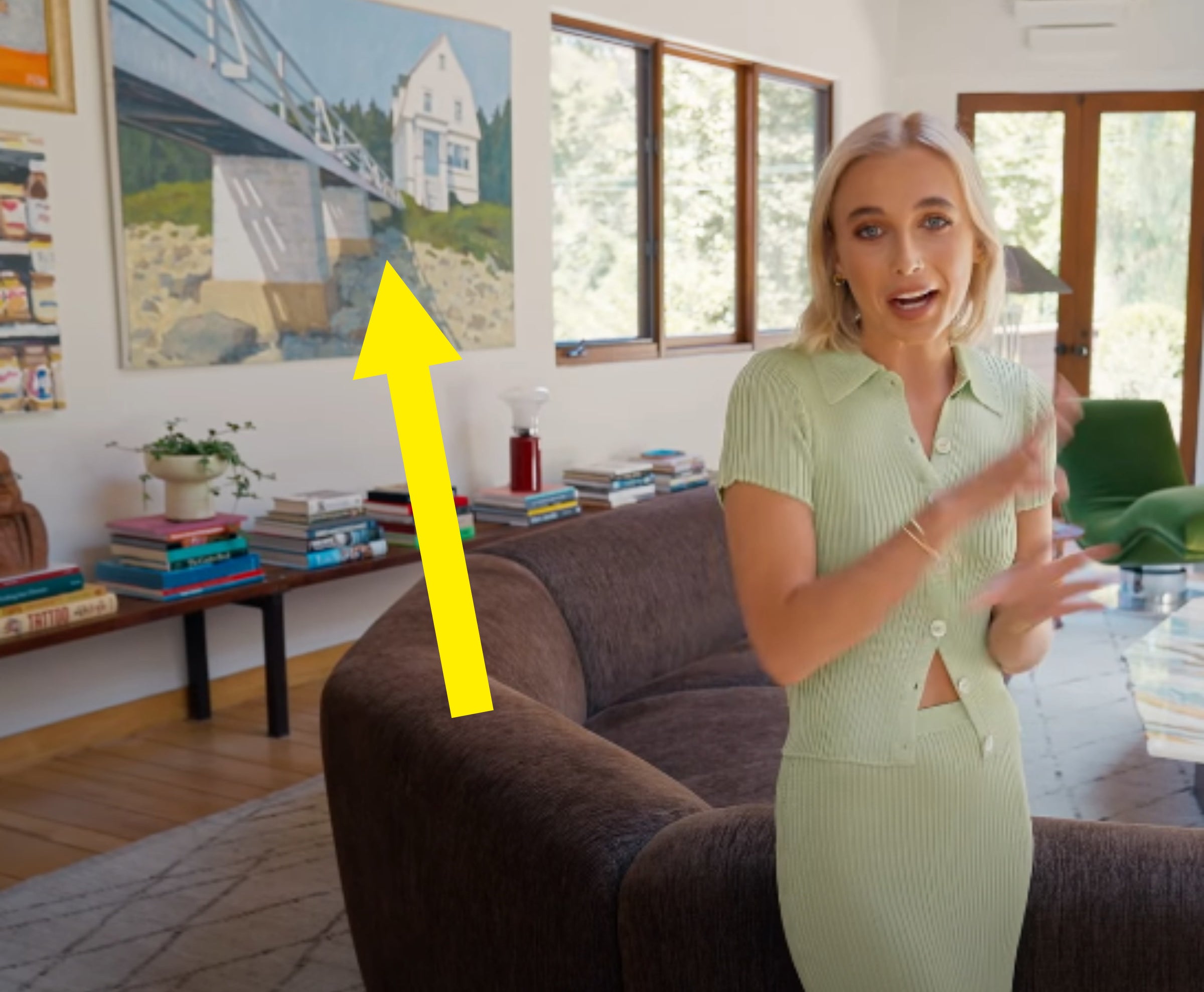Emma in her home with an arrow pointing to one of her dad&#x27;s paintings