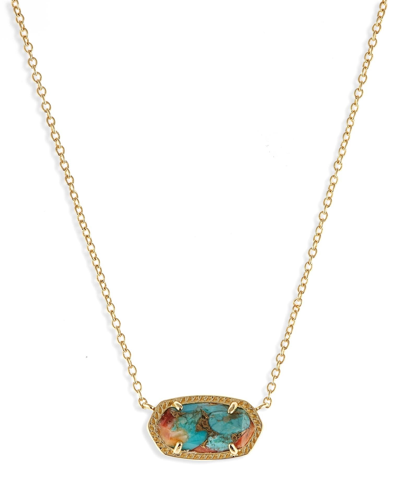 A close up image of the necklace with a turquoise and red pendant and gold chain
