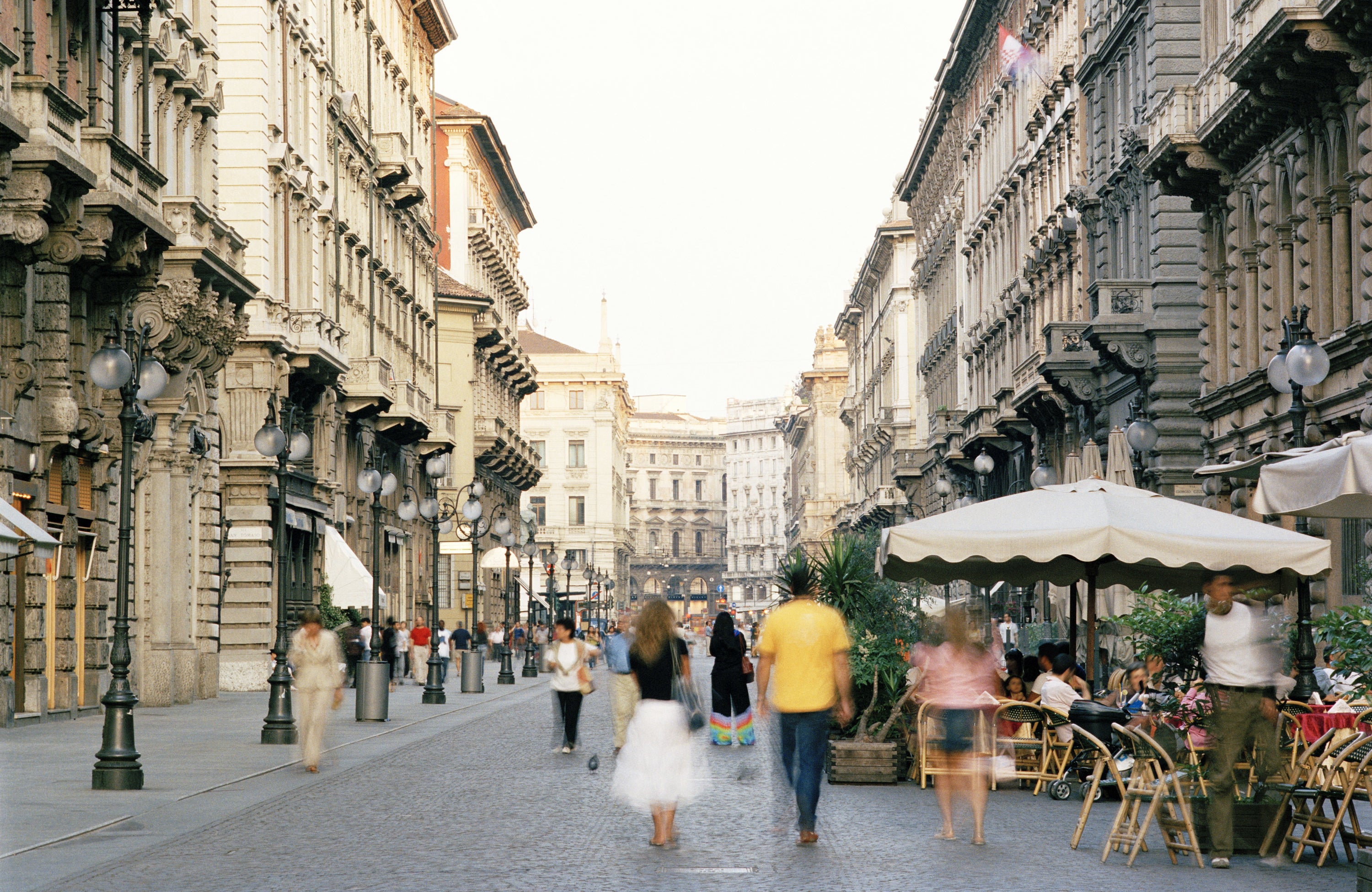 people walking down a street in Milan