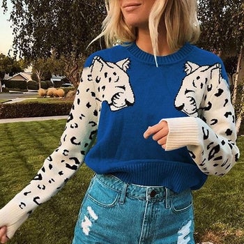 model wearing a blue sweater with leopard design on the sleeves