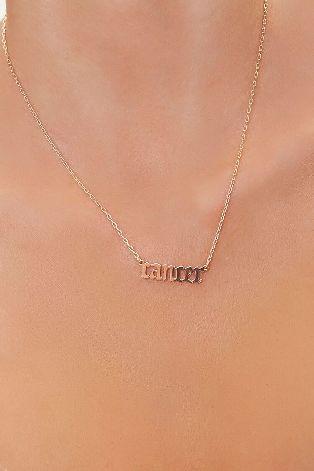 Model wearing necklace that says &quot;cancer&quot;