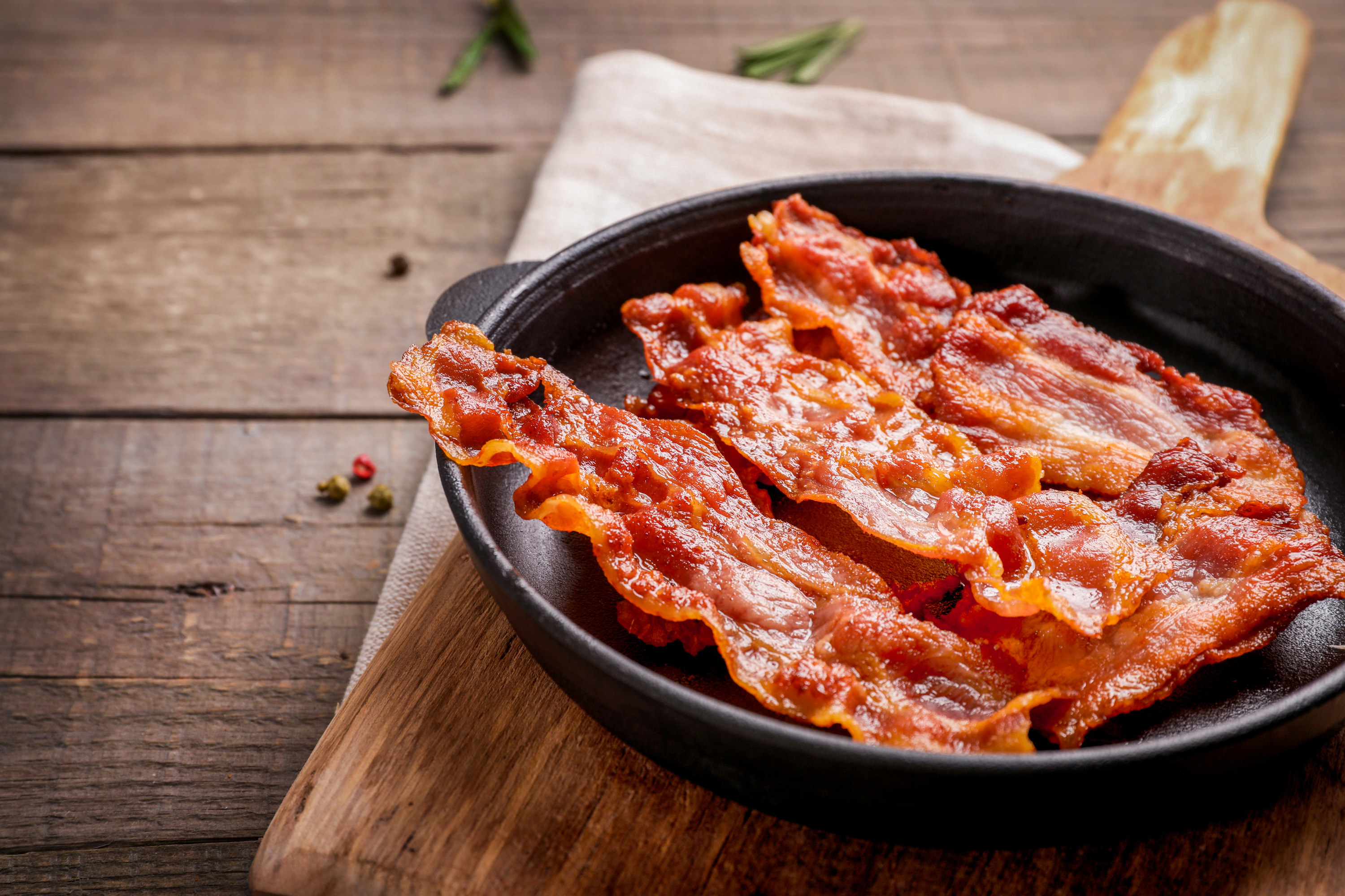 Hot fried crispy bacon slices in skillet