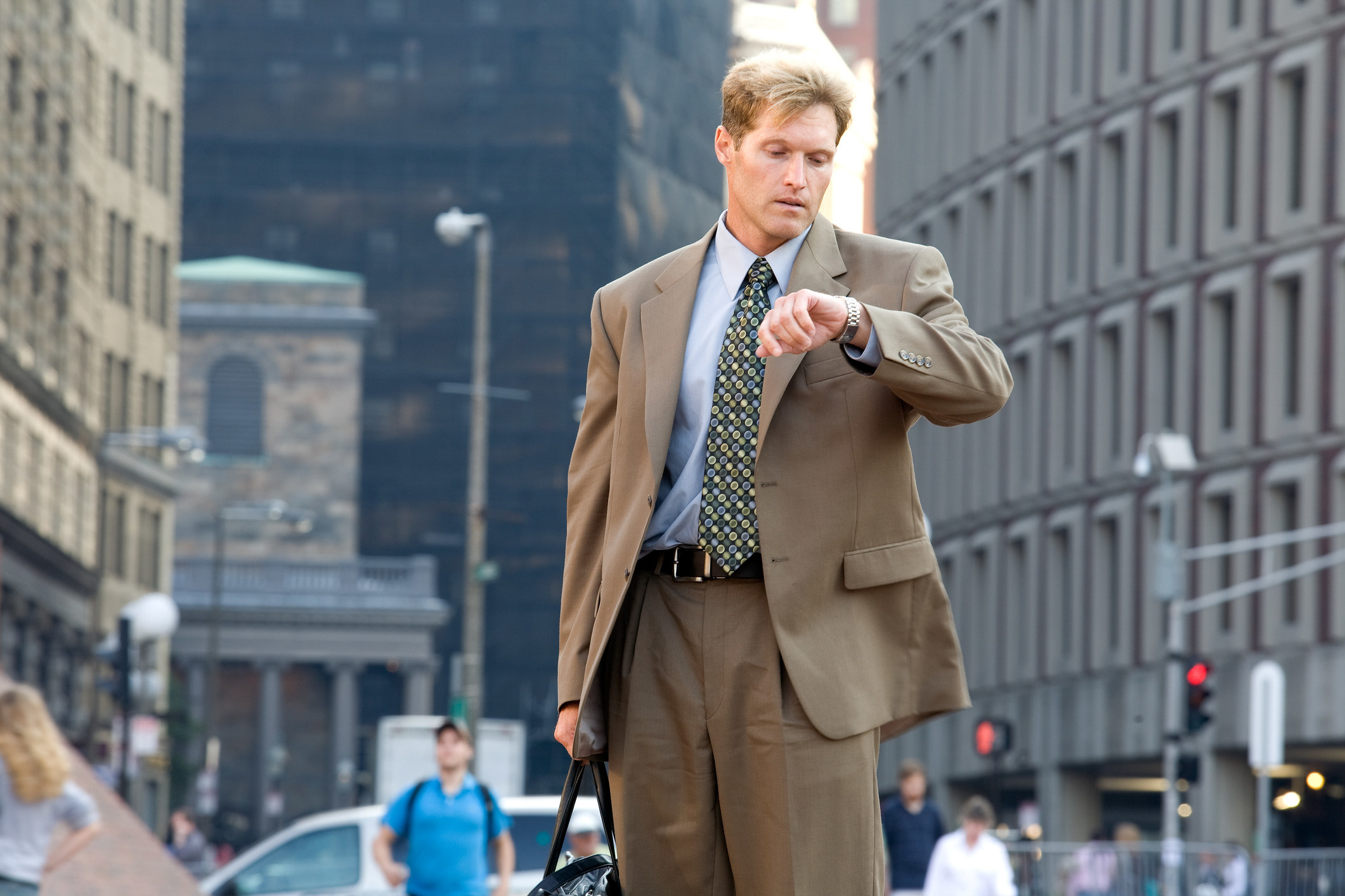 a man looking at his watch on a city street