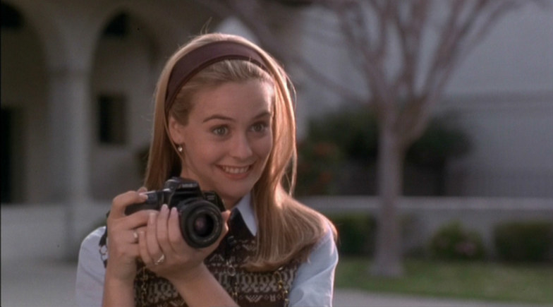 a girl holding a camera and smiling