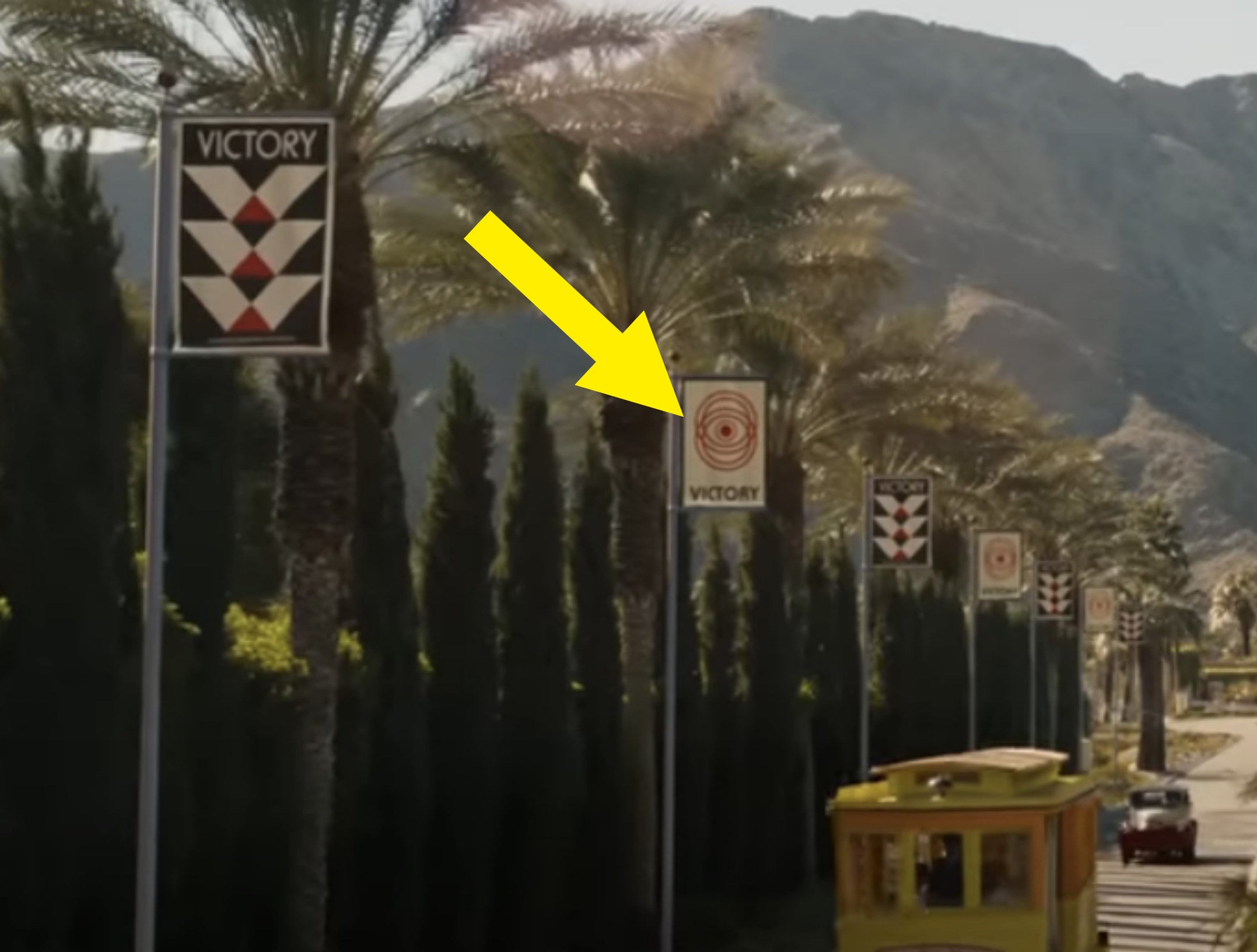 An arrow points out a sign on the side of the road that says &quot;Victory&quot; with an eye logo
