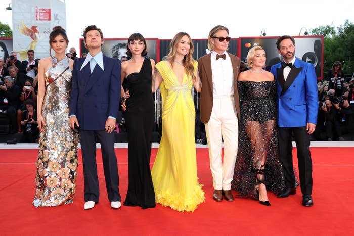 Seven cast members, including director Olivia Wilde, pose on the red carpet