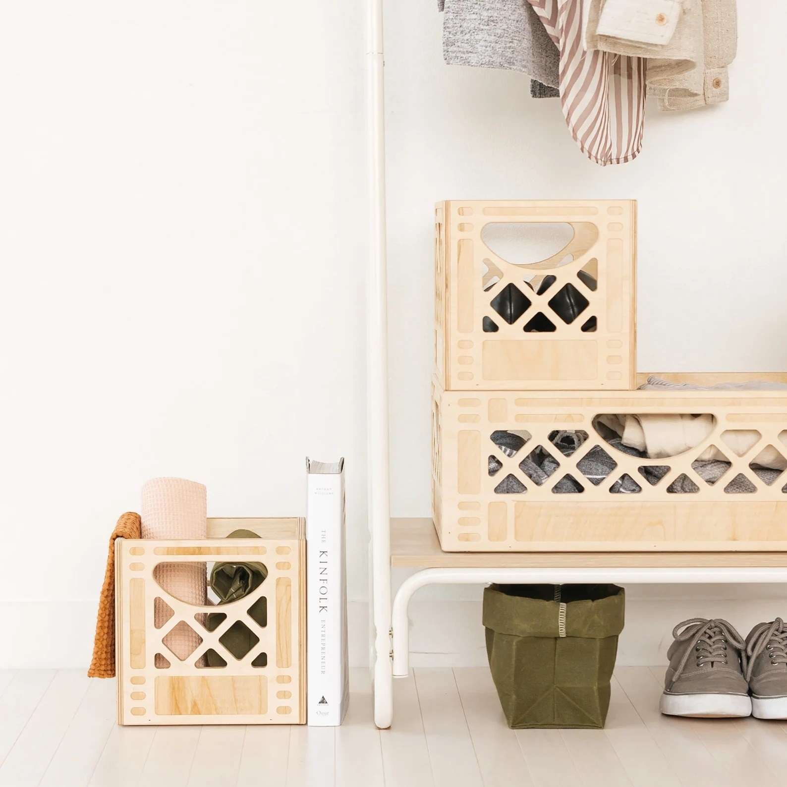 A set of maple wood milk crates are shown storing things in a bedroom