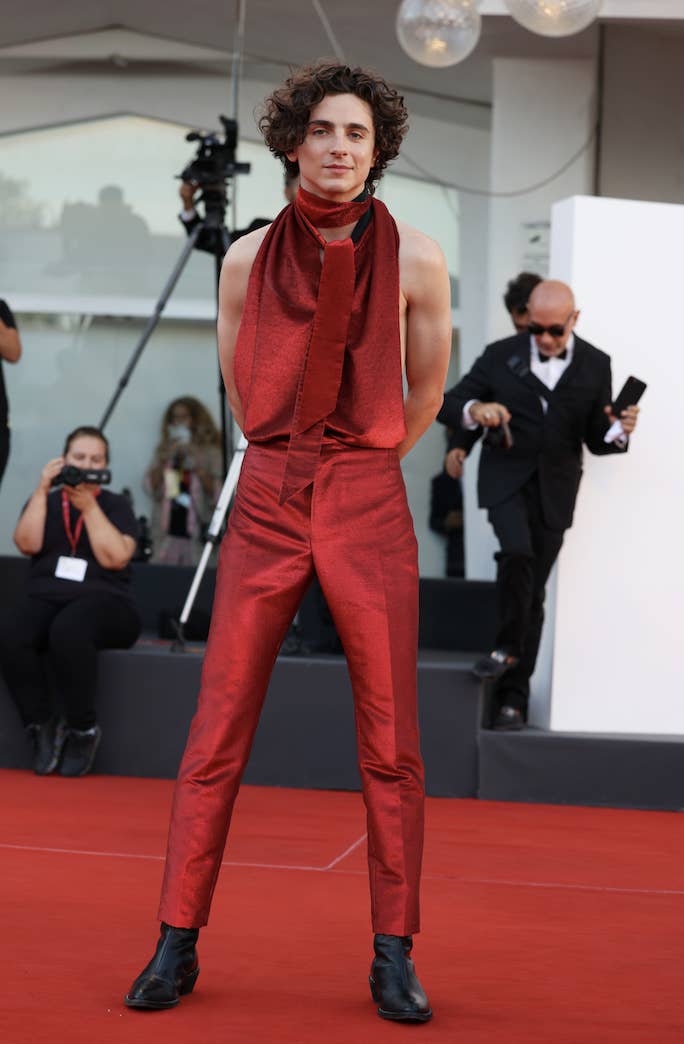 timotee wearing an all-red outfit with the top of the shirt being sleeveless and has a large tie neck