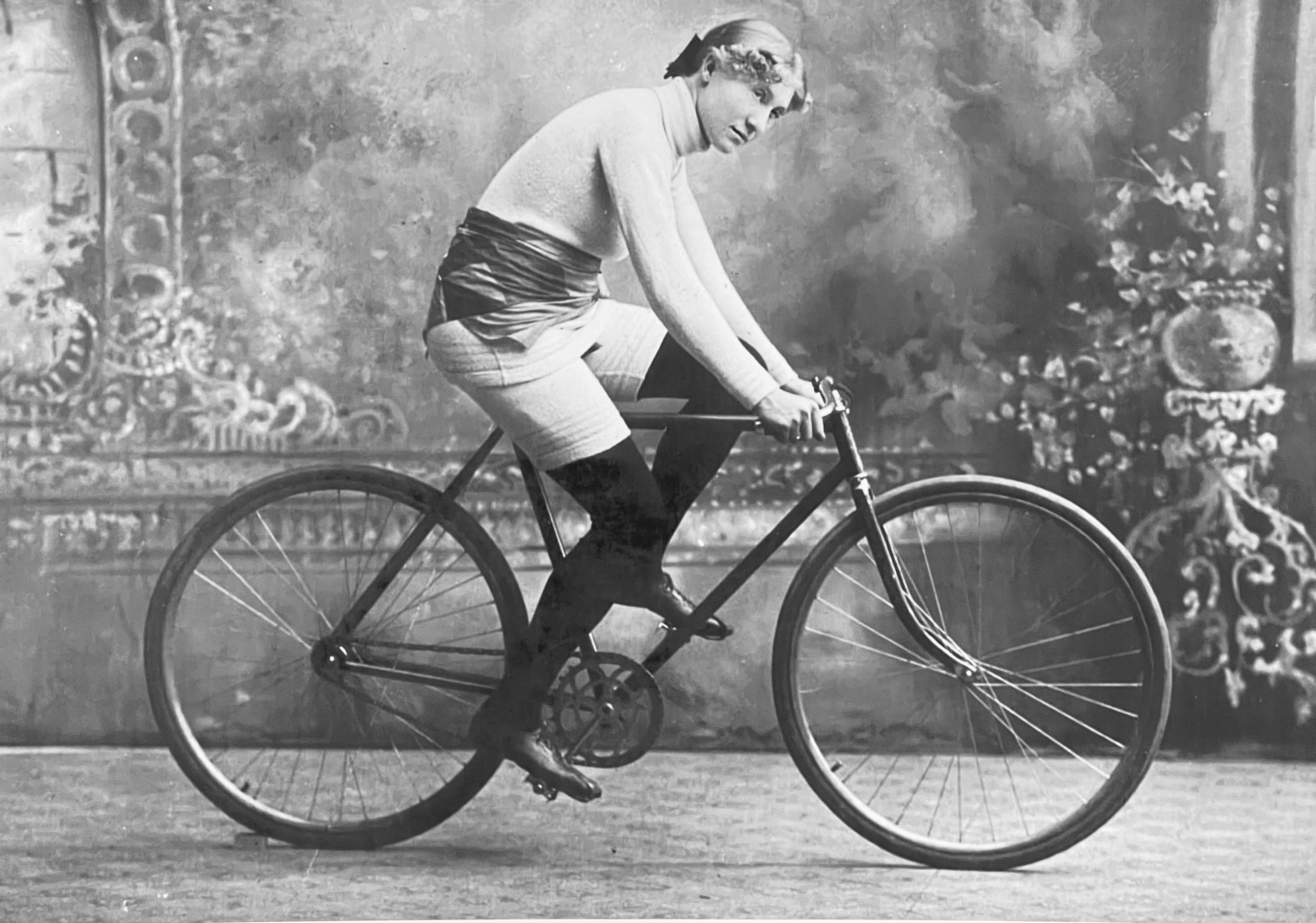 Black-and-white photo of a woman riding a bike