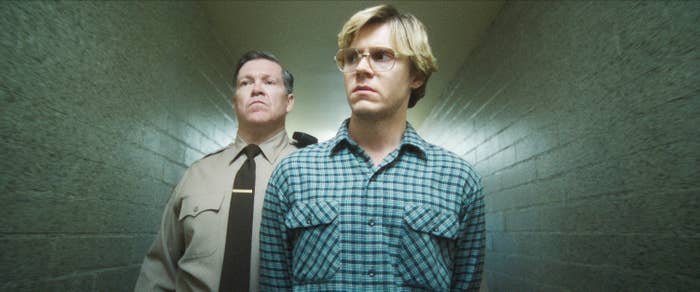 Evan as Jeffrey walking with a police officer in a hallway