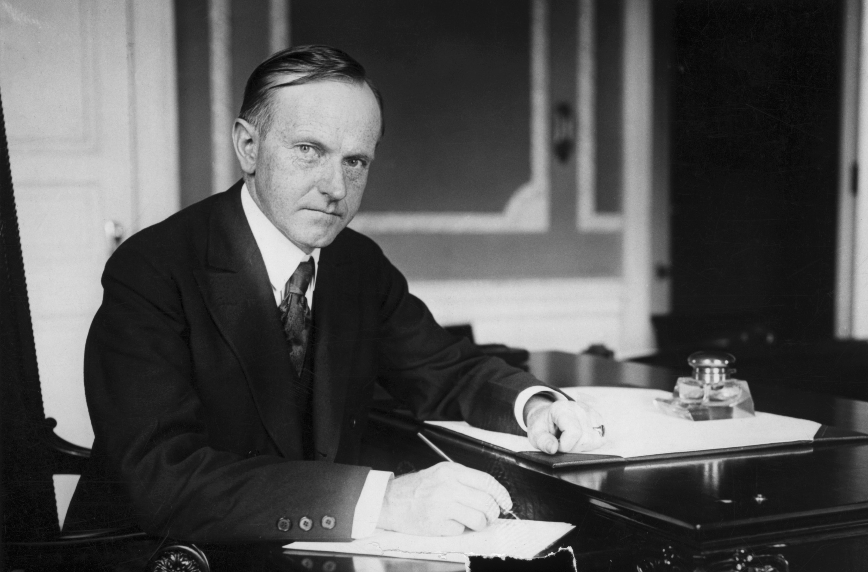 Coolidge sitting at a desk