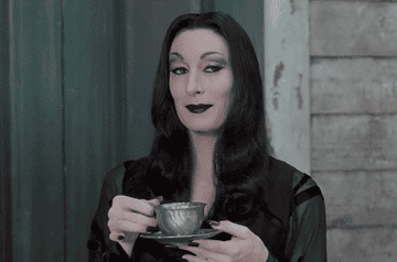 Morticia Addams with a coffee mug