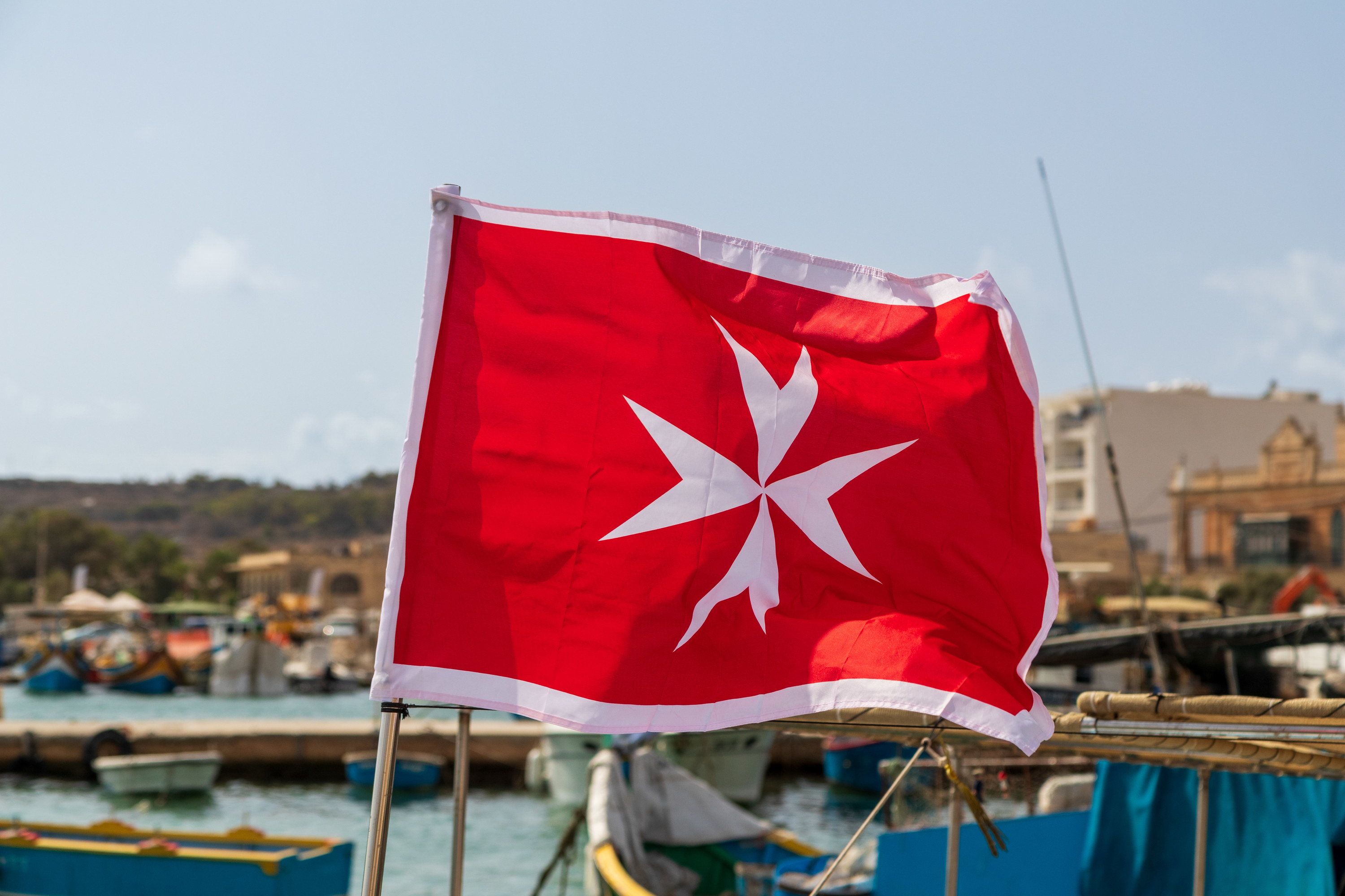 Marine flag of Malta flying, a white-red flag with a George Cross