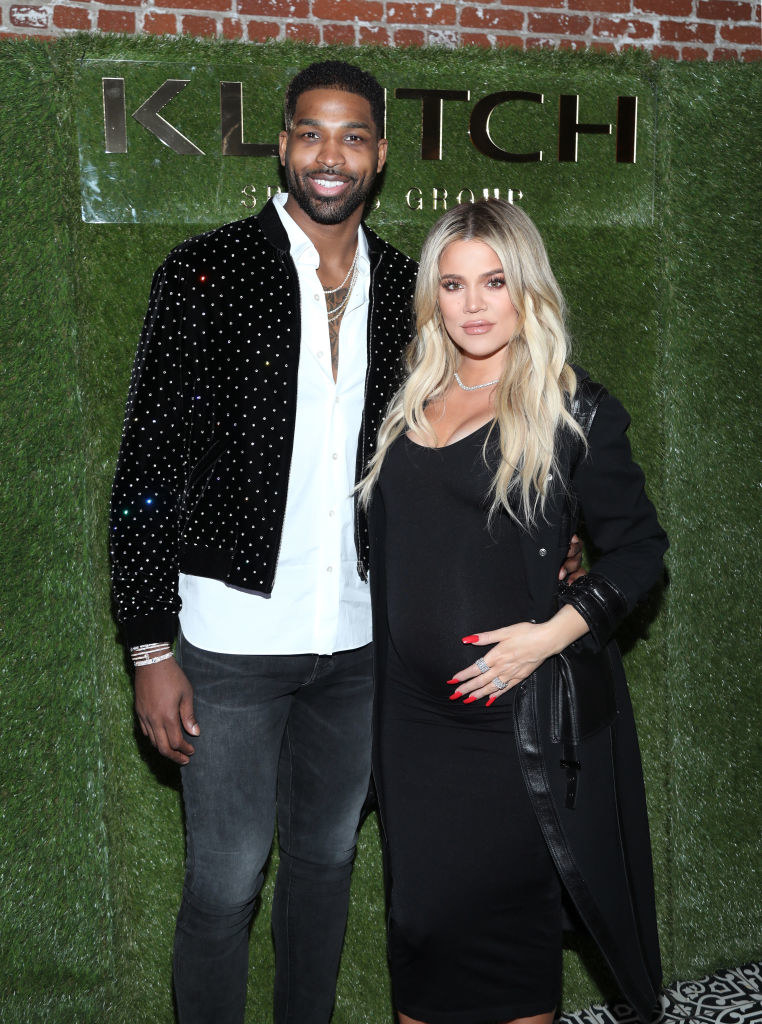 the couple at an event with Khloe&#x27;s hand on her pregnant stomach