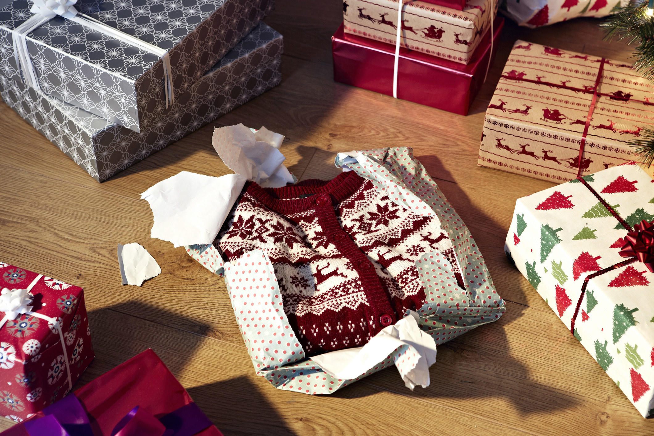 A holiday sweater partly opened in gift wrap