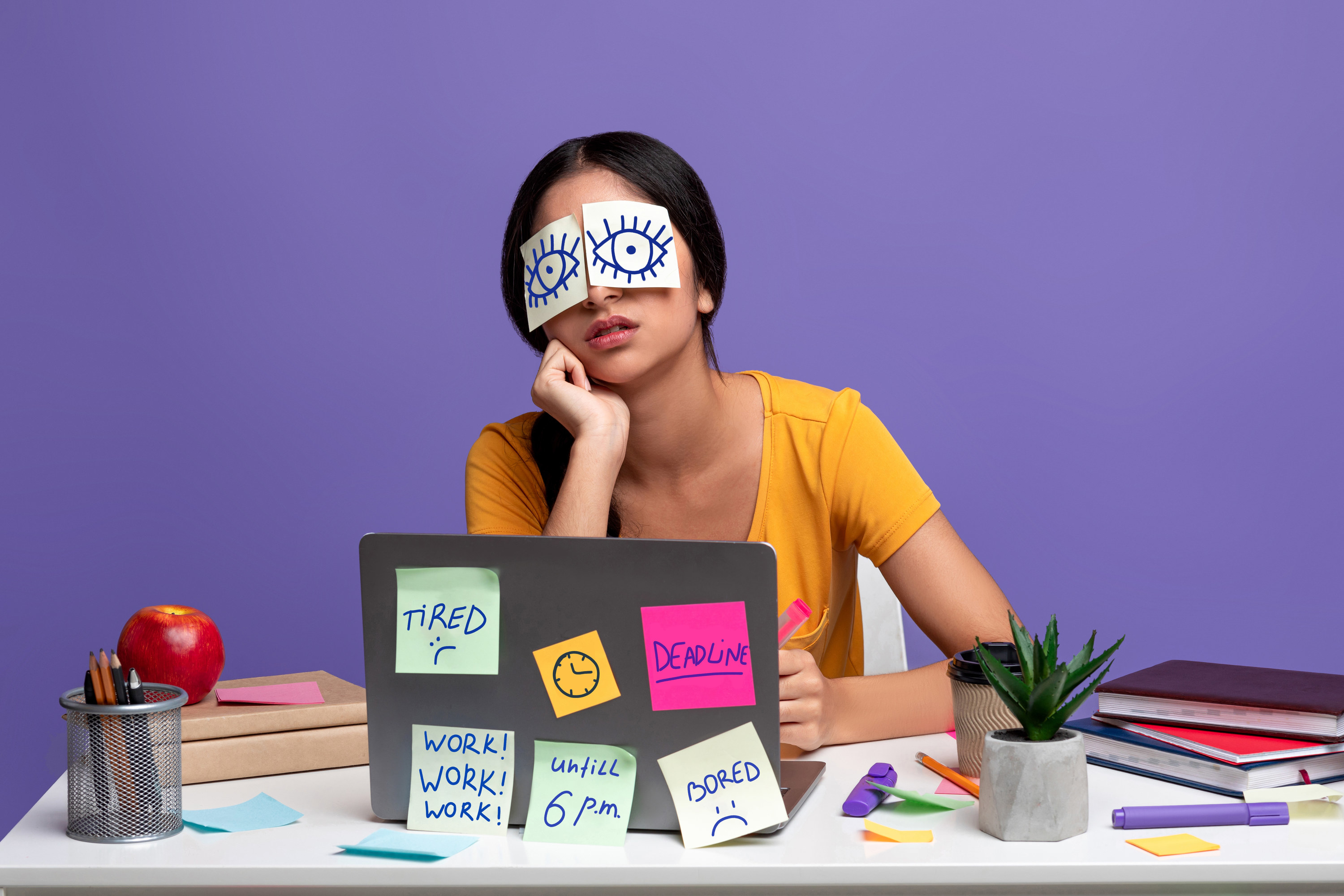stressed out woman with post-it notes all over her computer and on her eyes