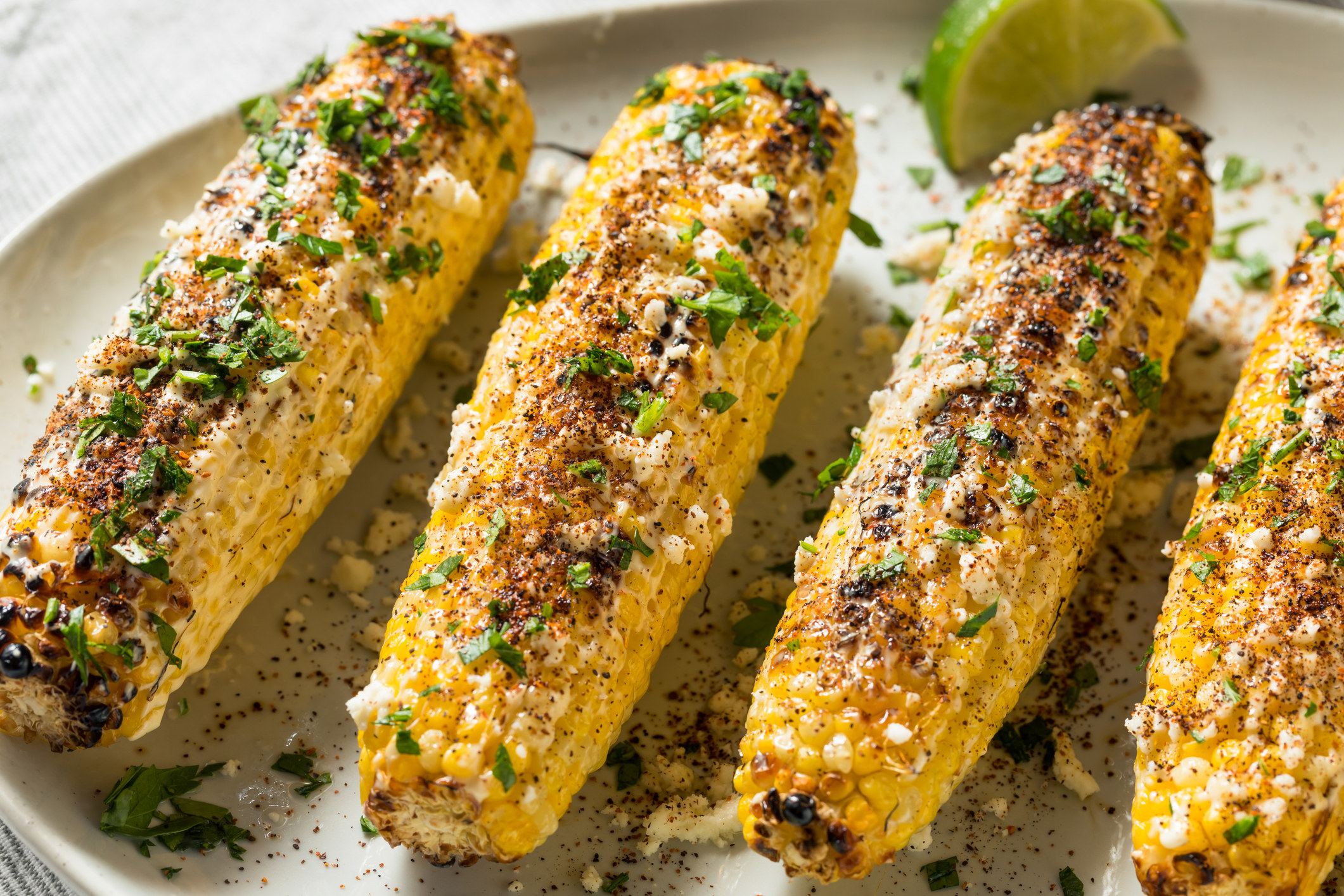 Four Mexican-style street corn on the cobs