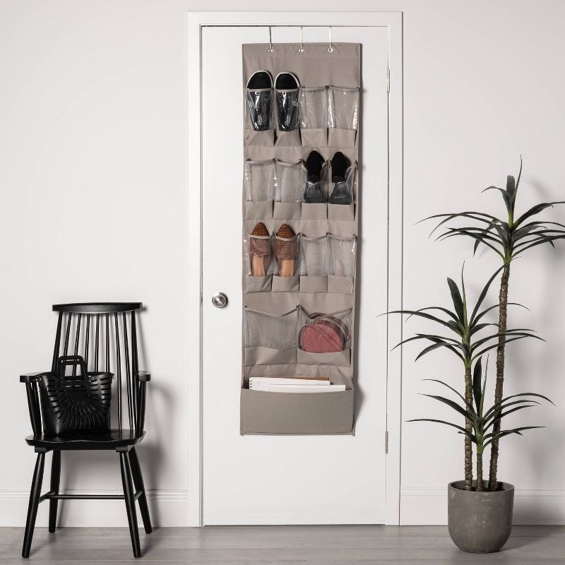 The organizer holding shoes and other items hanging over a door