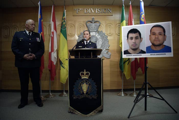 Police officer stands at the podium next to headshots of two men