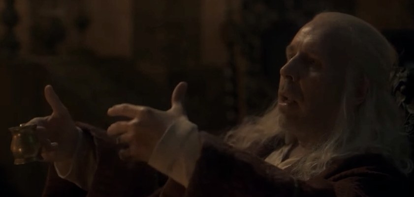 Viserys gestures with his hands; one is missing two fingers