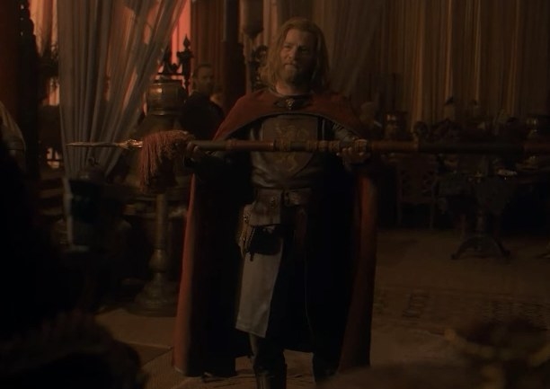 Jason holds up a spear as a gift for the king