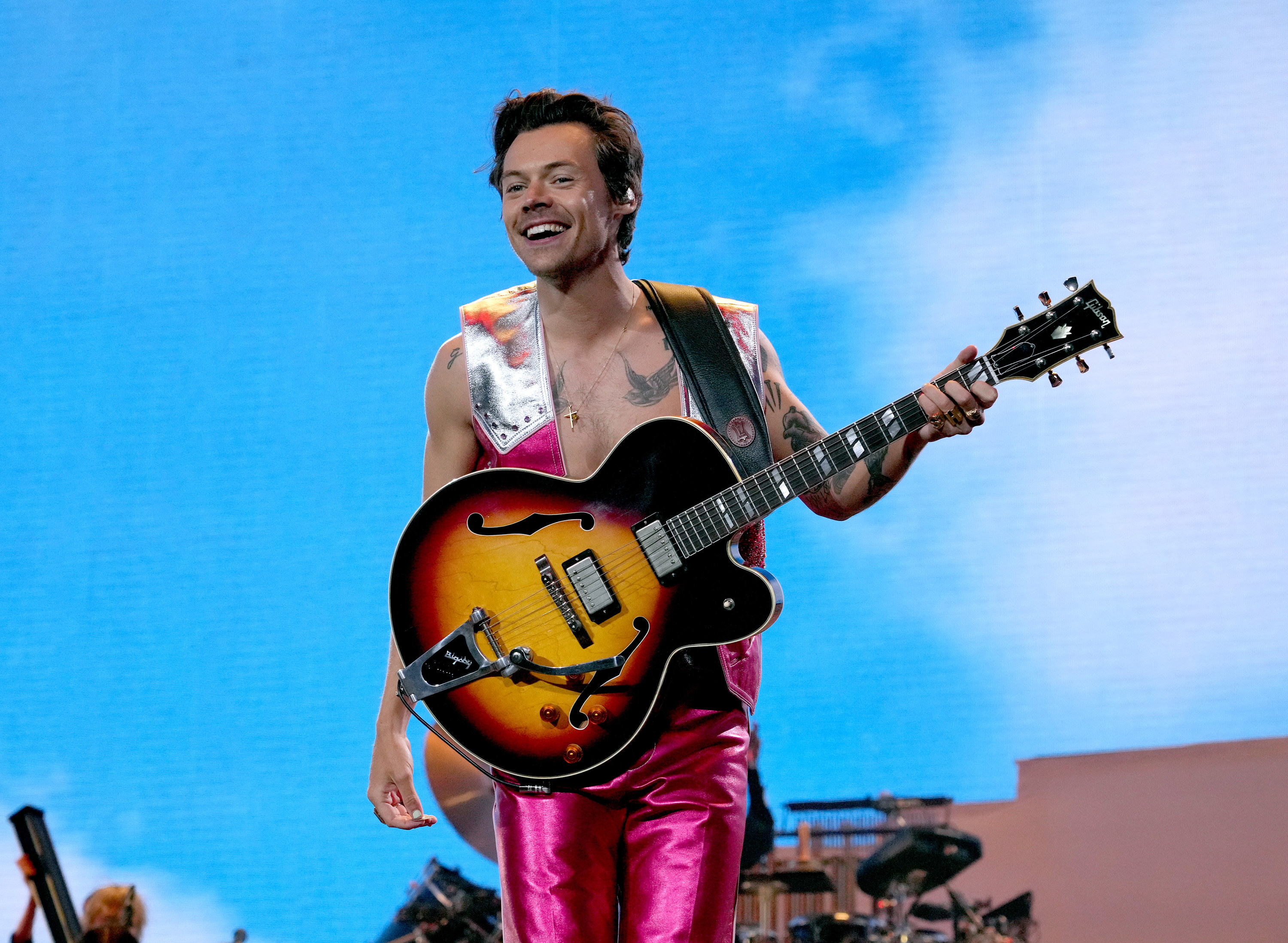 Harry Styles performing onstage with a guitar