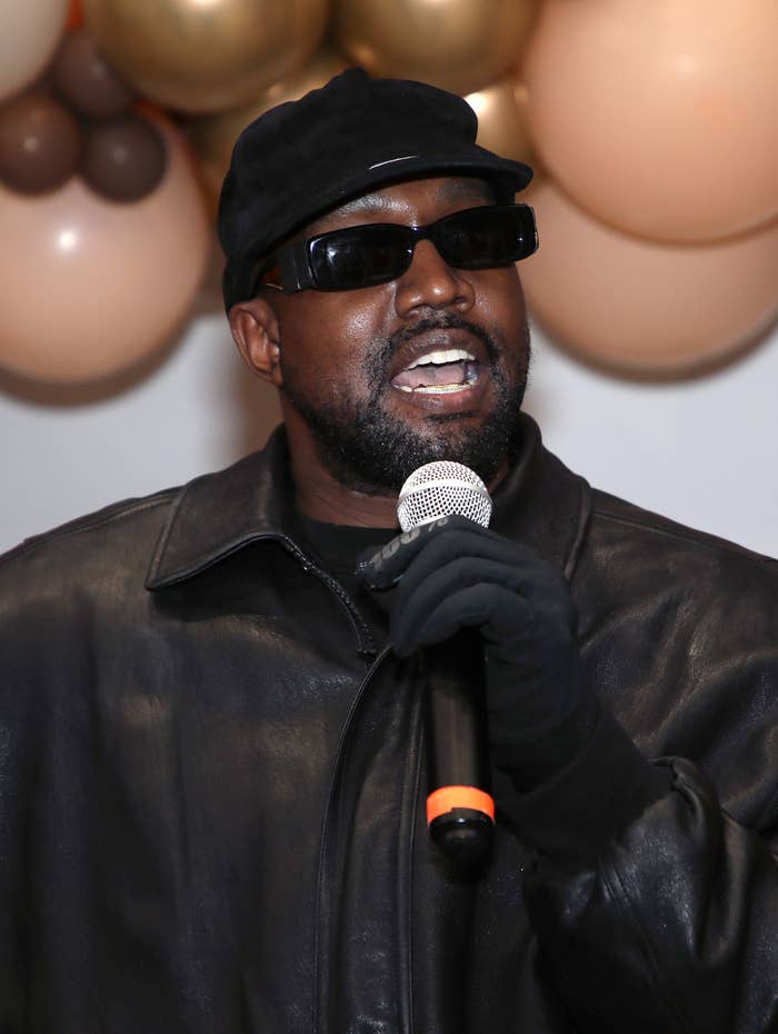 Kanye wearing sunglasses at a microphone