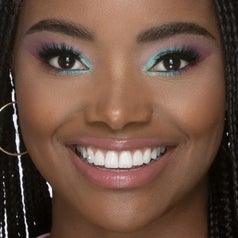 Model with a teal and pink eyeshadow look around their brown eyes