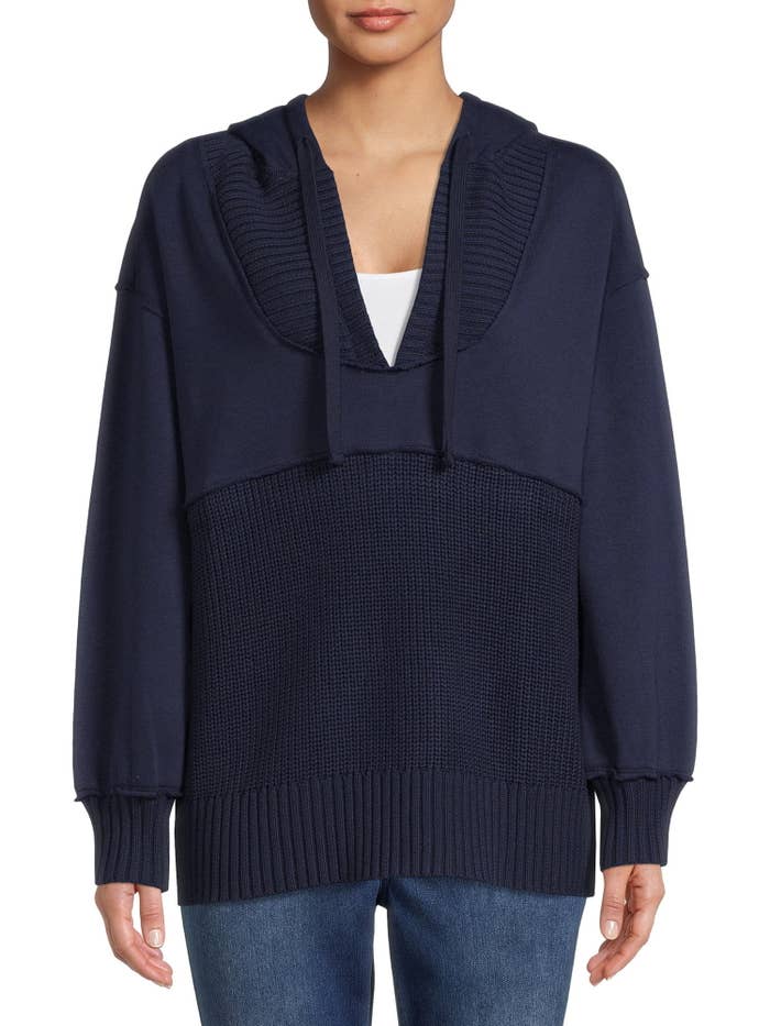 Model wearing navy pull over hoodie with jeans