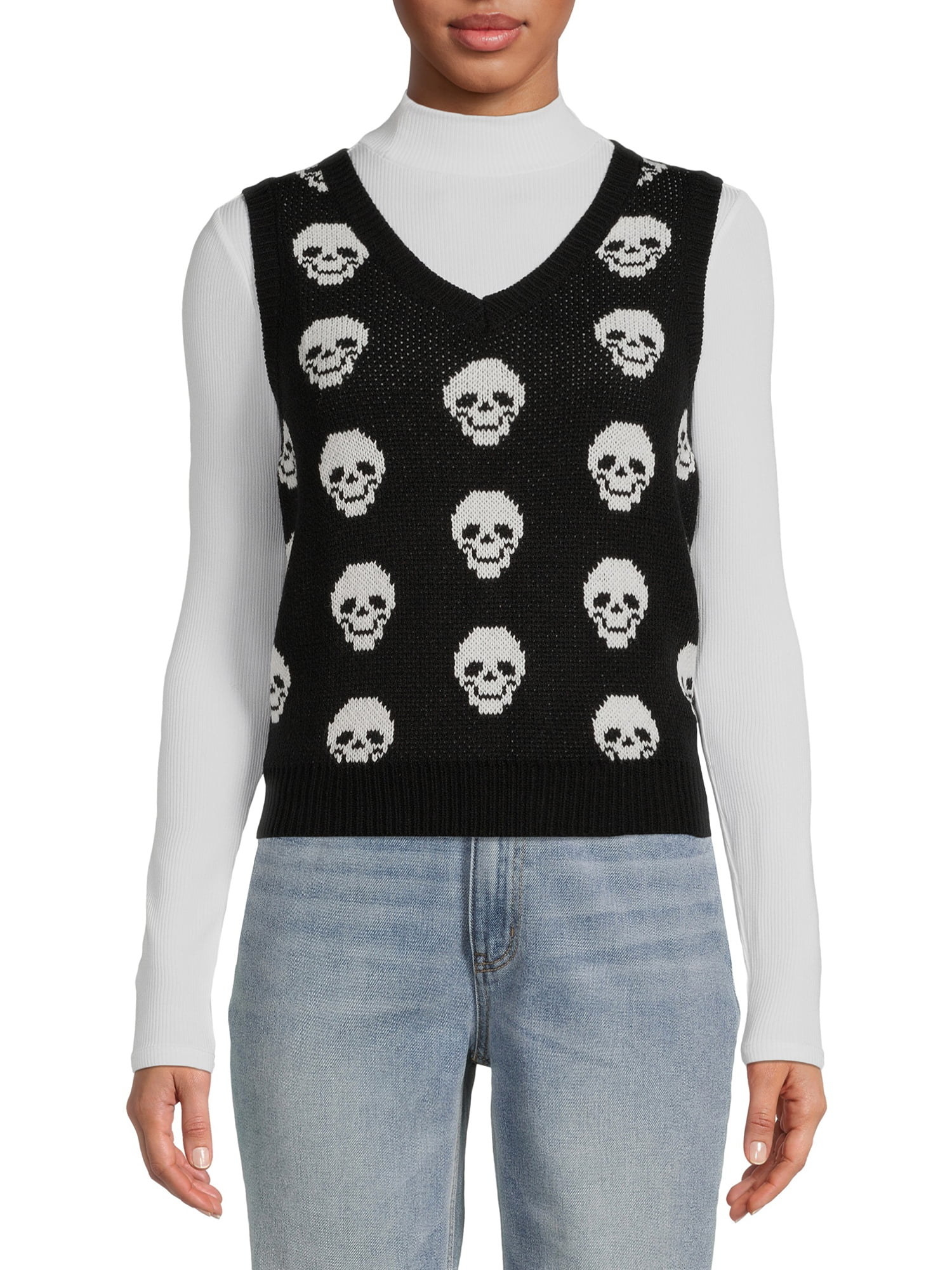 Model wearing black vest with white skulls on it, long sleeve white shirt underneath and blue jeans