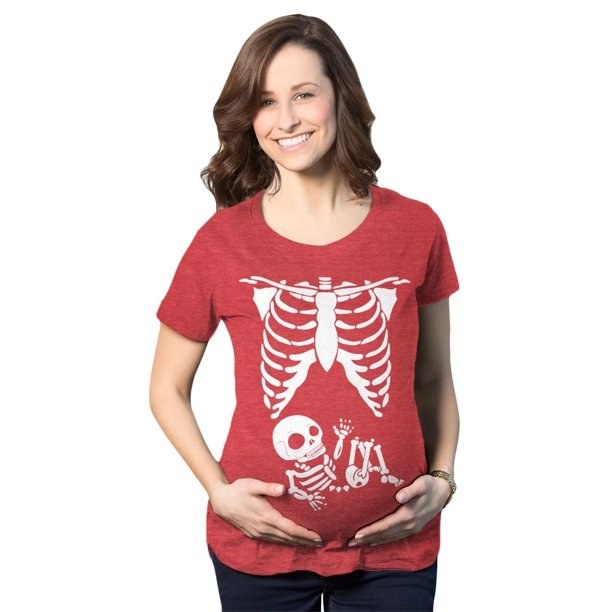 Pregnant model wearing red T-shirt with white rib cage and baby skeleton graphic on it