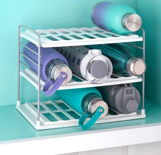 the two tier bottle shelf with various water bottles on it