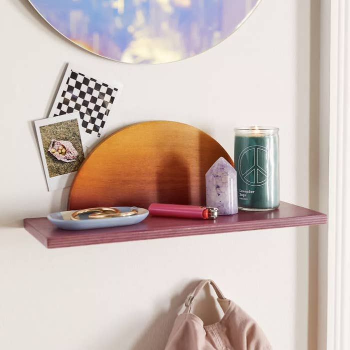 The shelf with a candle, crystal, and catchall dish on it