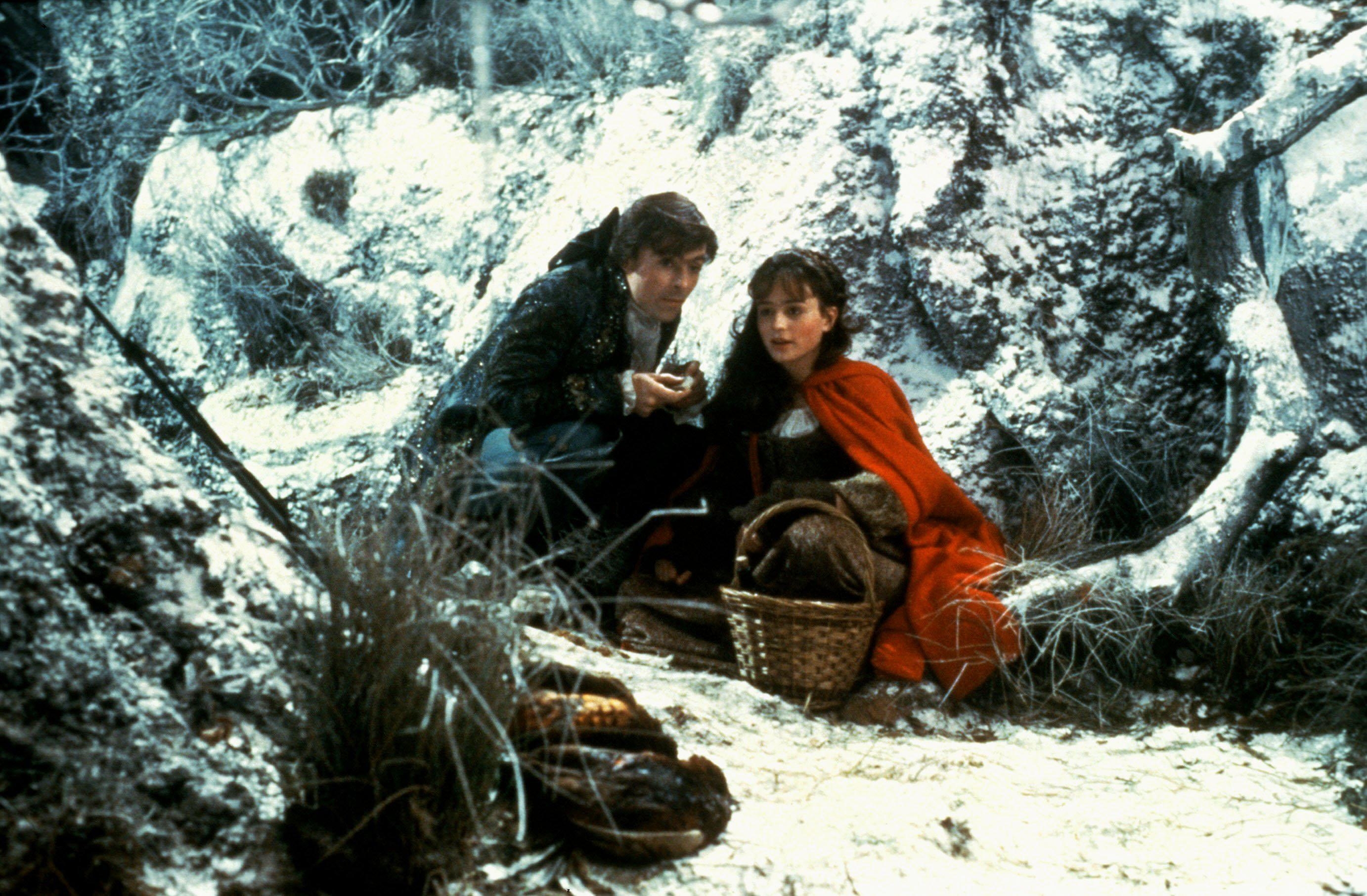 A young woman and her potential suitor picnic in a snowy woodland in &quot;The Company of Wolves&quot;