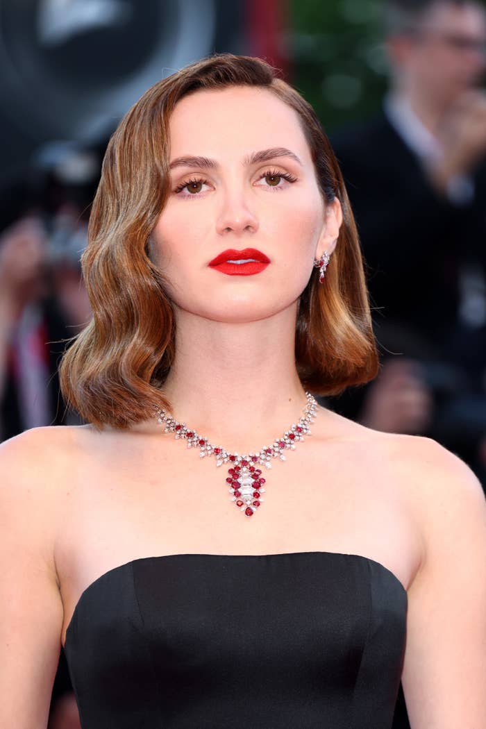 Maude at an event wearing a strapless outfit and a multicolored diamond necklace