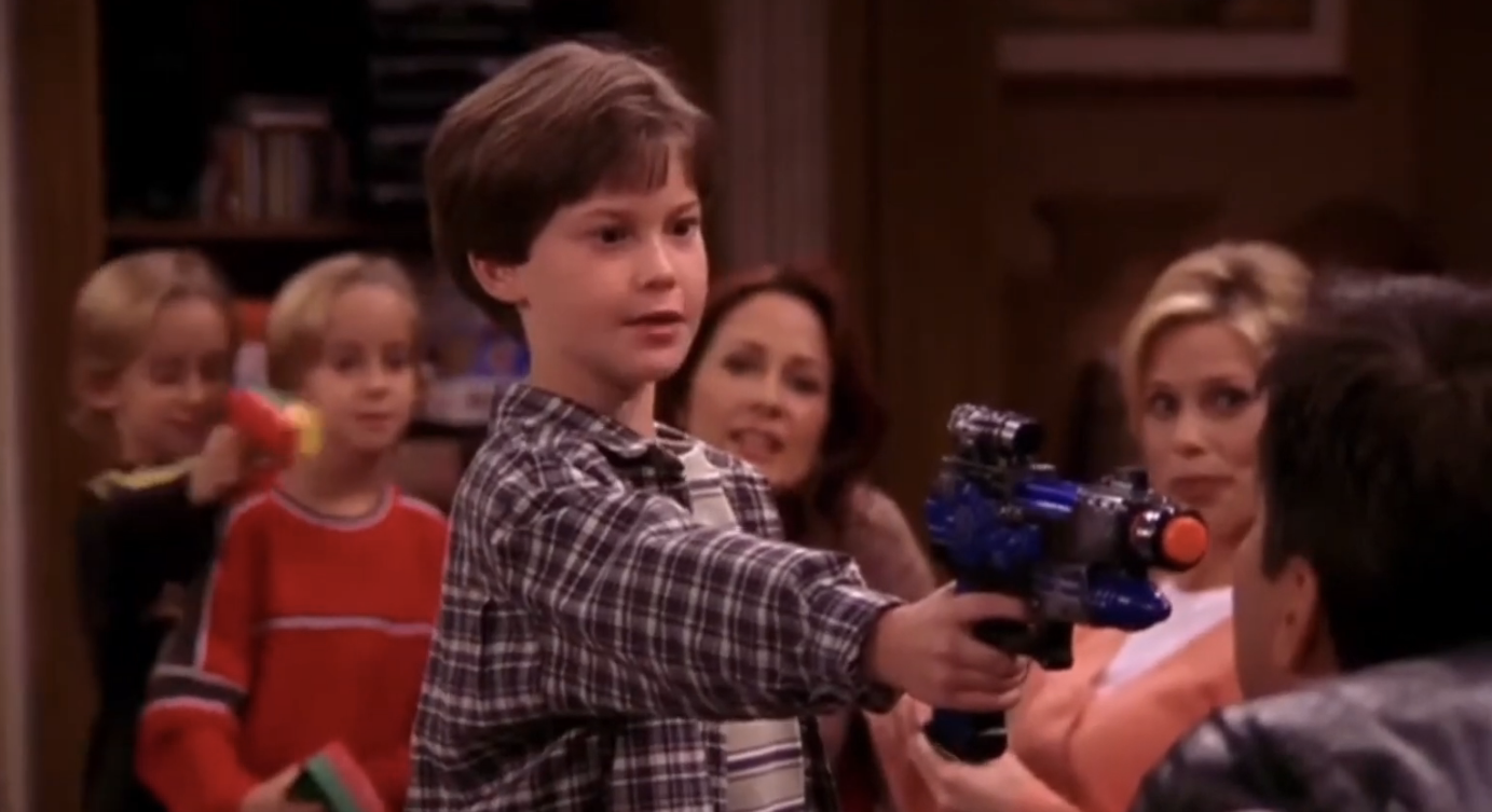 kid pointing a toy gun at an adult