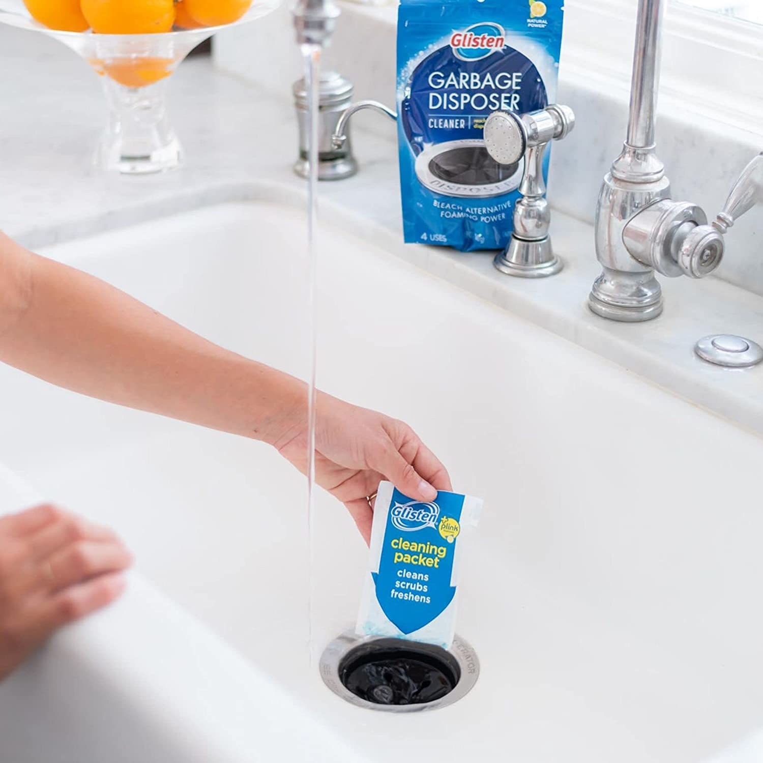 A person putting a cleaning packet in their sink drain