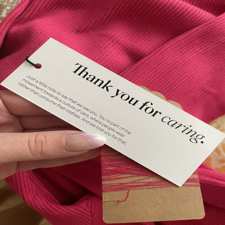 a close-up of a tag from the seam, text reads: thank you for caring