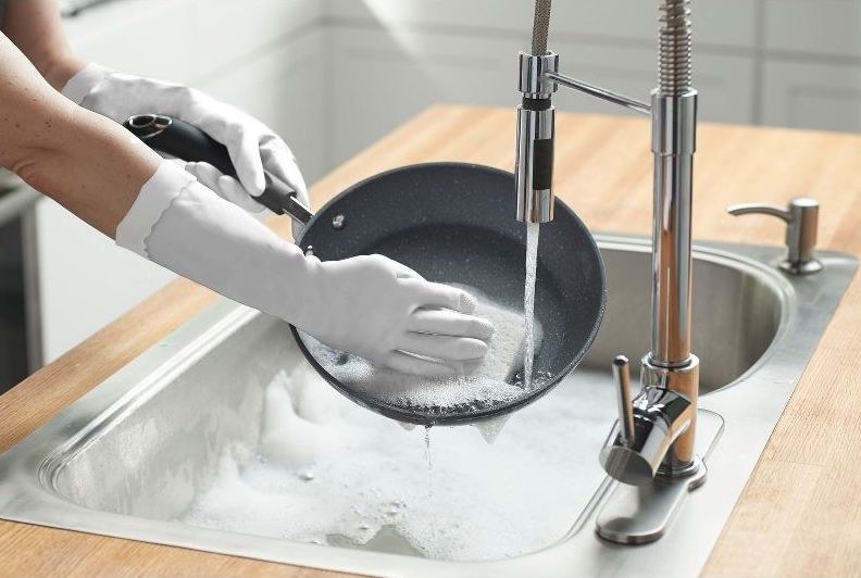 a person wears the gloves while washing dishes