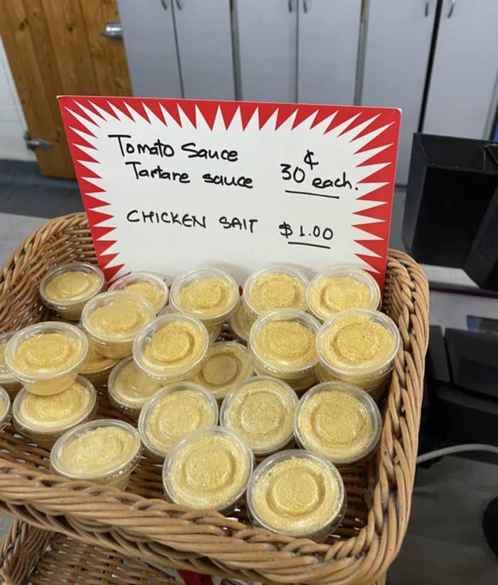 A basket of chicken salt in plastic containers, being sold for $1 each
