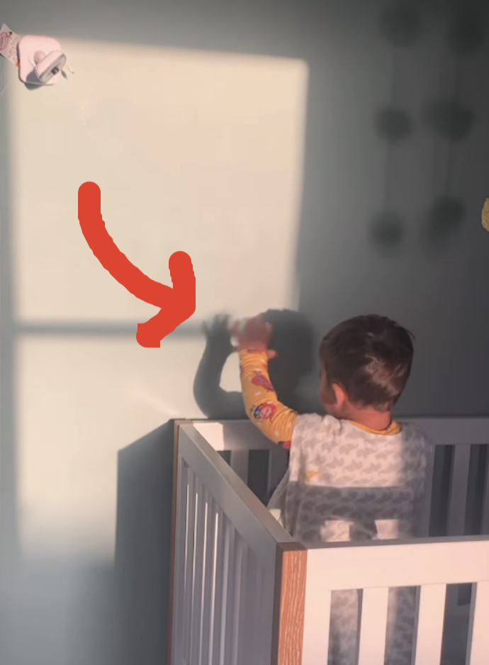 spencer waving from his crib at his shadow