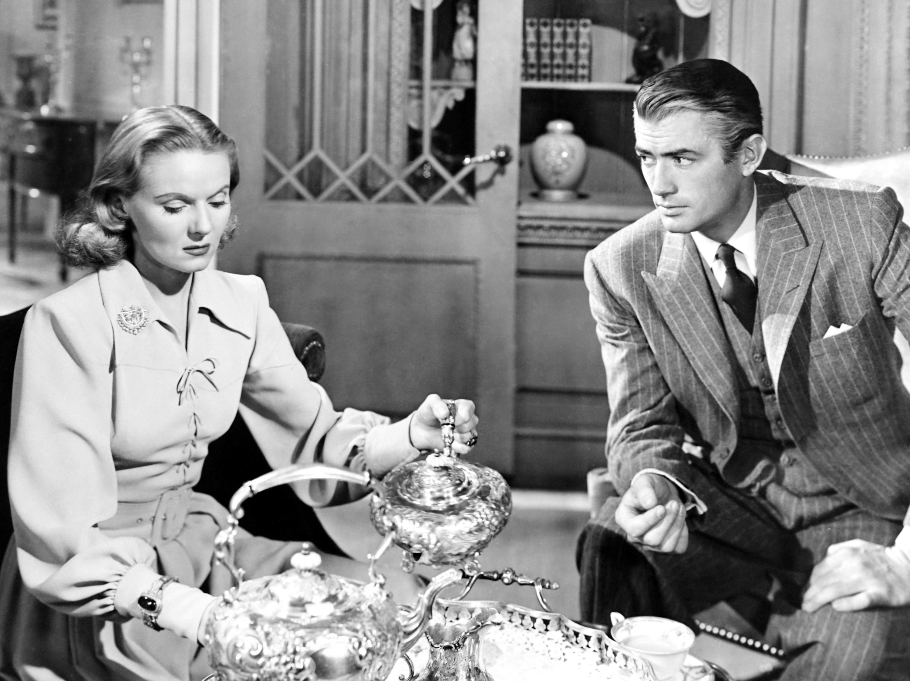 Ann Todd pouring tea while Gregory Peck stares at her.