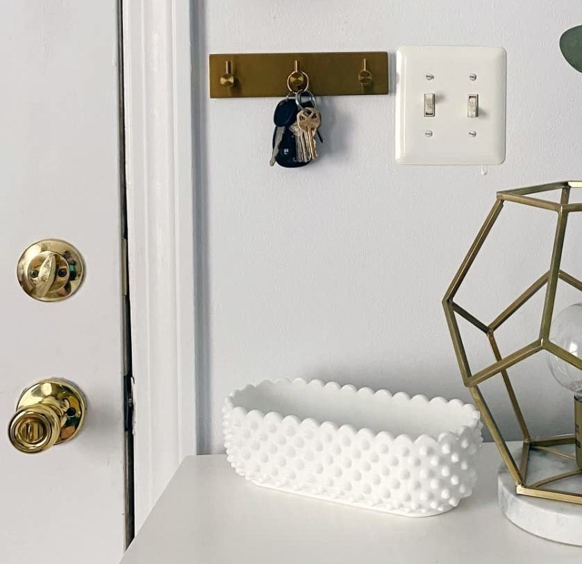 Reviewer image of gold key hooks on entryway wall next to the door