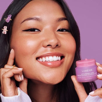 model holding small pink tub of Laneige Lip Sleeping Mask in Gummy Bear