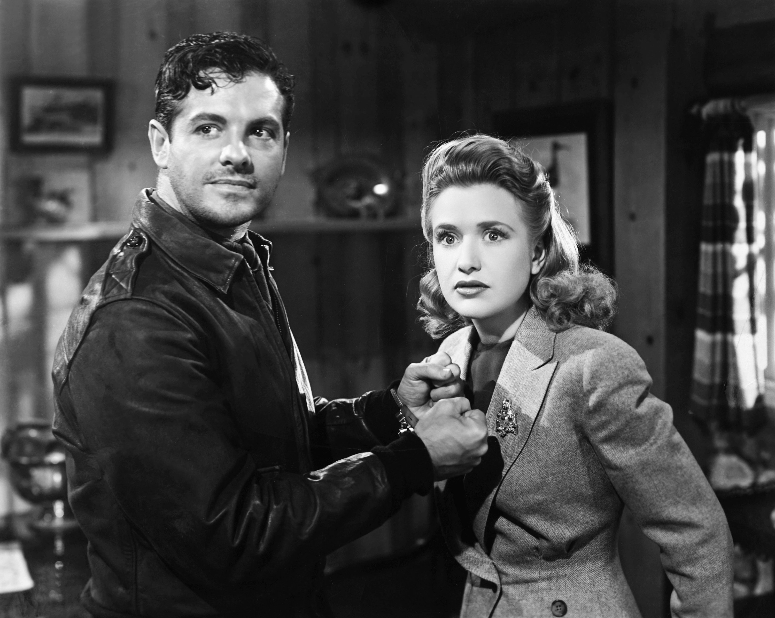 Robert Cummings and Priscilla Lane staring at something.