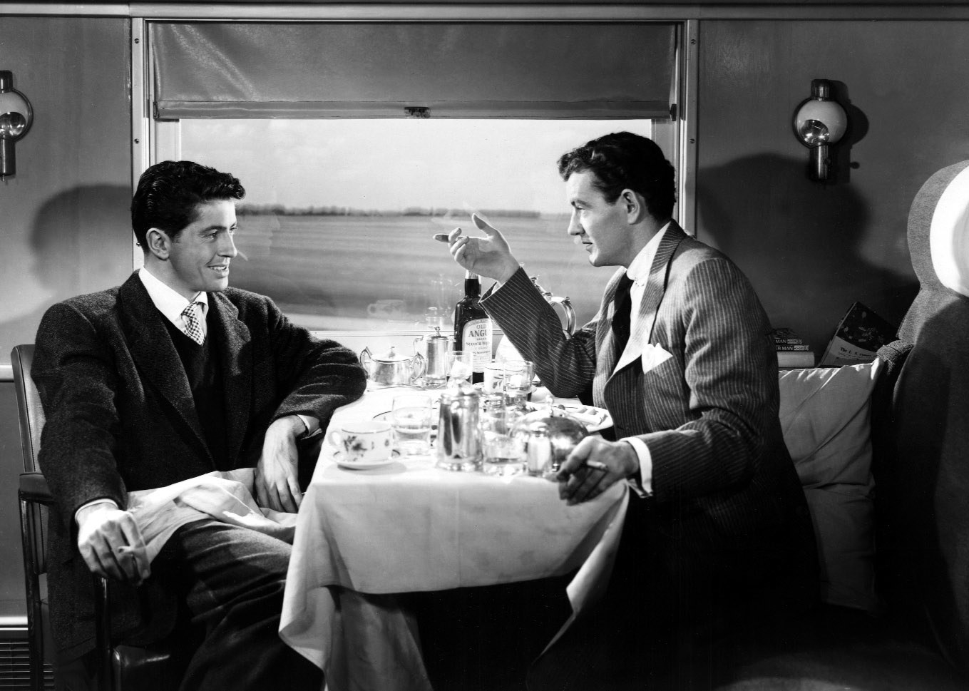 Farley Granger and Robert Walker sitting in a train.