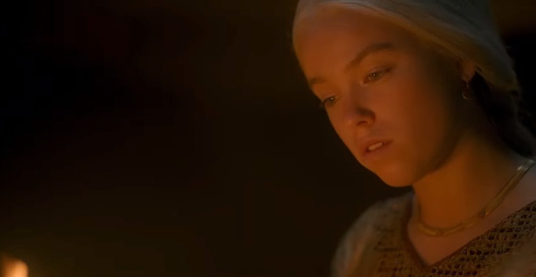 Rhaenys looks down, lit by fire light