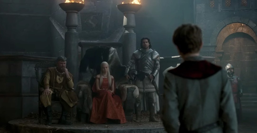 Rhaenyra sits flanked by a Baratheon and Ser Criston Cole talking to what appears to be a young boy