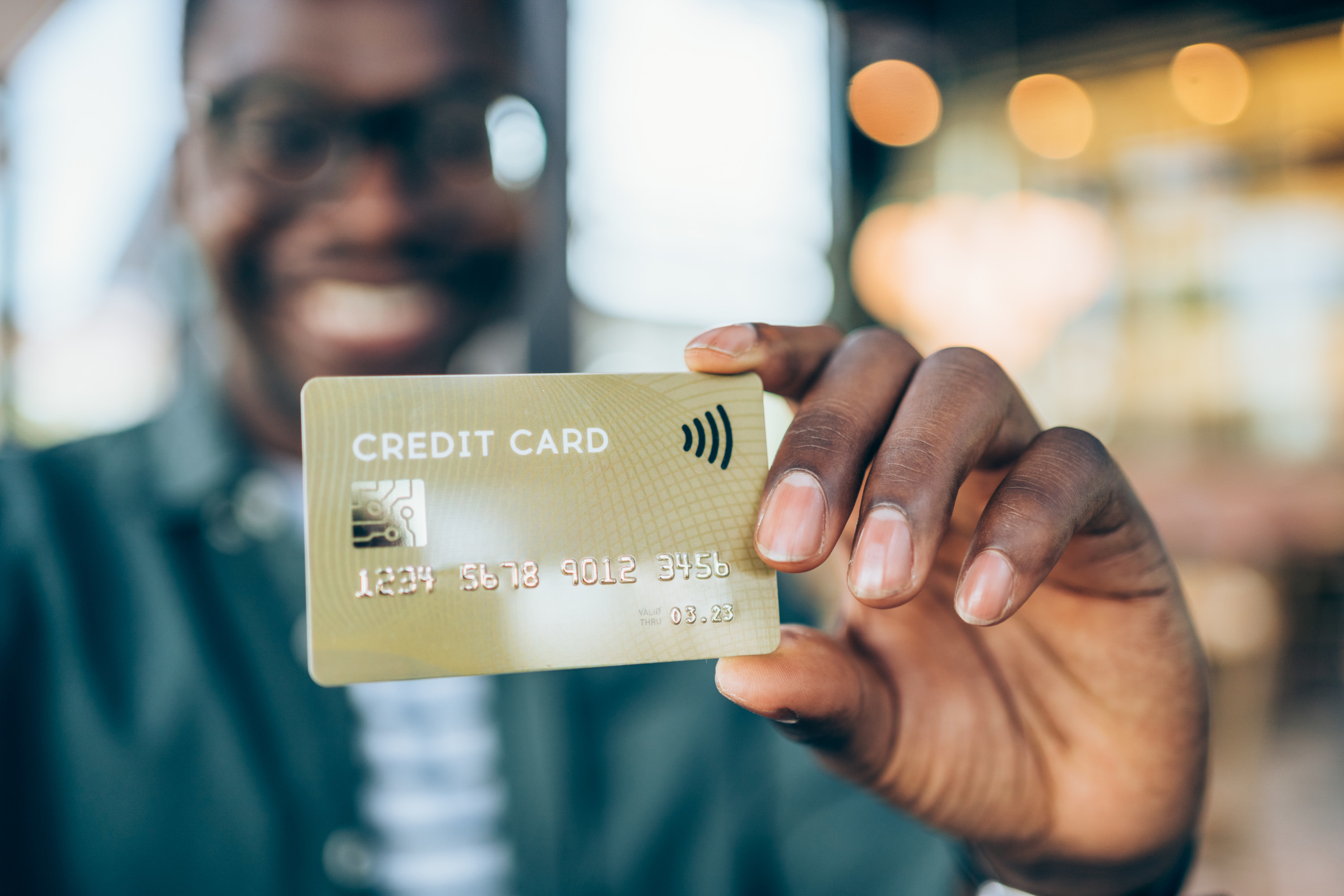 Man holds a credit card toward the camera