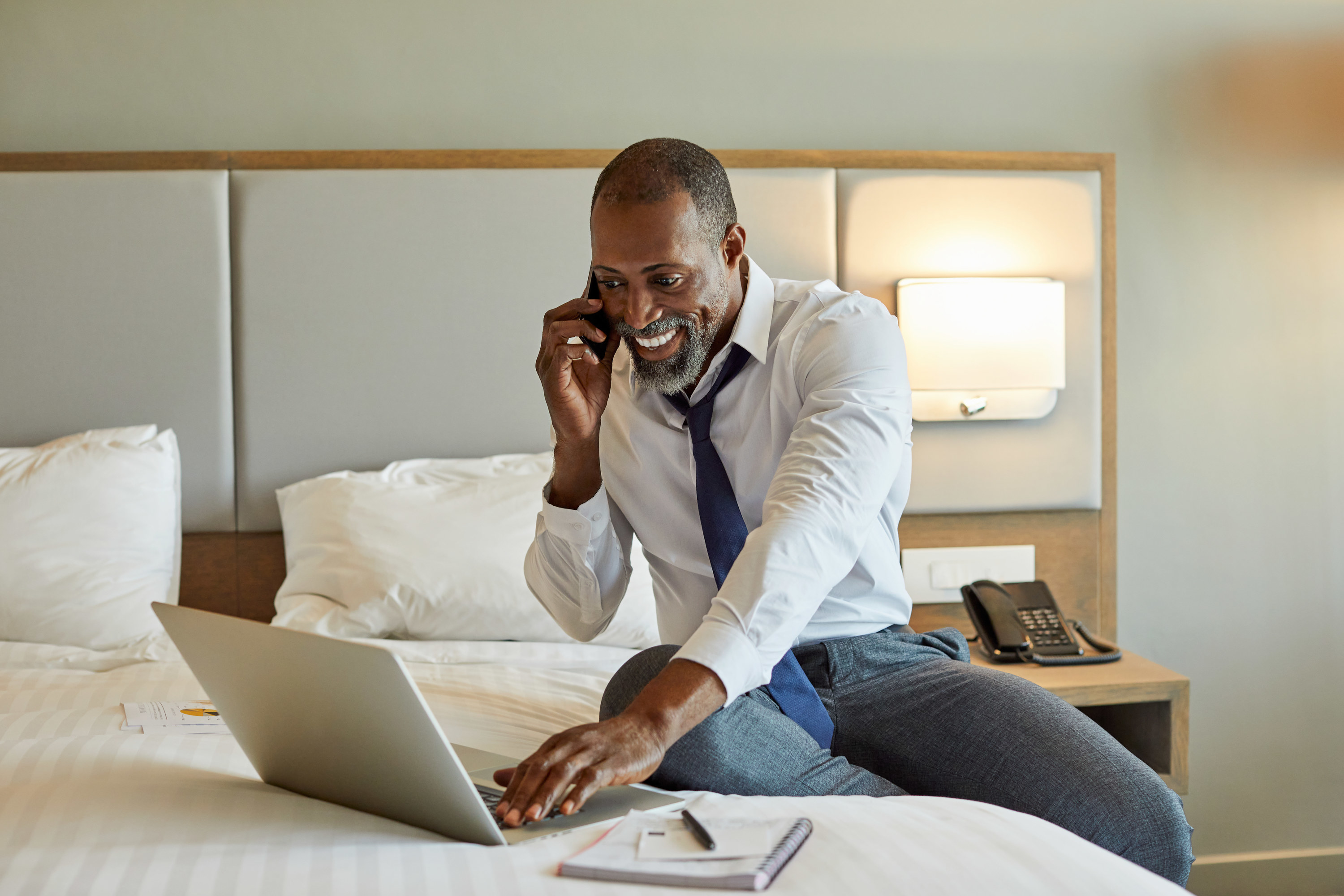 Man looks at his computer in a hotel room